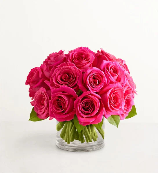 Fresh hot pink roses bouquet in a clear low vase